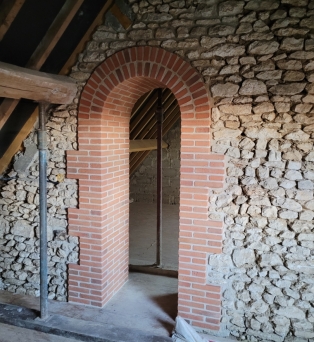 Percement de mur en pierre et création d'une arche en briques vieillies à Francourville
