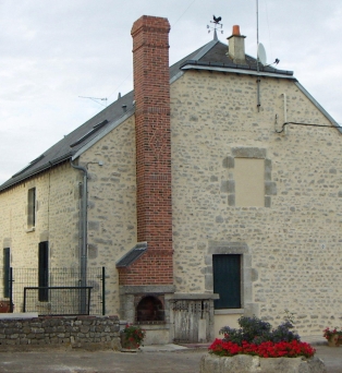 Réfection de façade en pierre apparente et cheminée en briques rouge flammée décorée