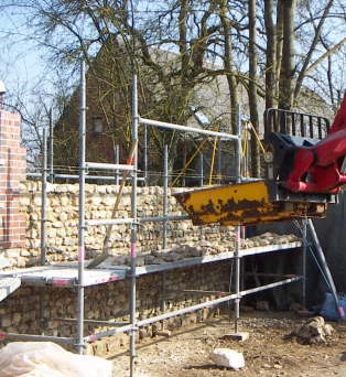 Construction de mur en pierres apparentes et briques rouge traditionnelles au mortier de chaux