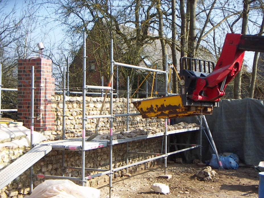 Construction de mur en pierres apparentes et briques rouge traditionnelles au mortier de chaux